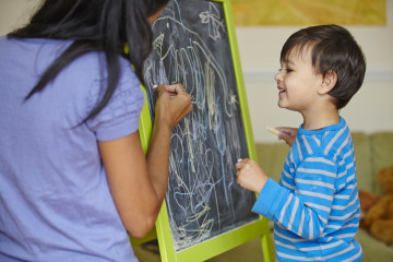 Mum and boy drawing on blackboard