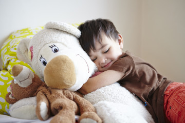 Boy cuddling a teddy