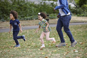 Children with dad running in the park