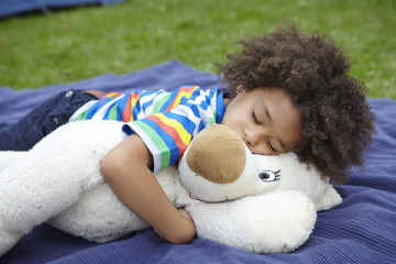Boy snoozes with teddy