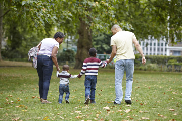 Mum, Dad and children walking in park