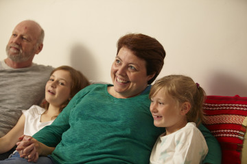 Mum, dad and daughters watching TV