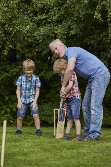 Dad and children playing cricket